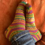 a person s feet in colorful socks sitting on a couch