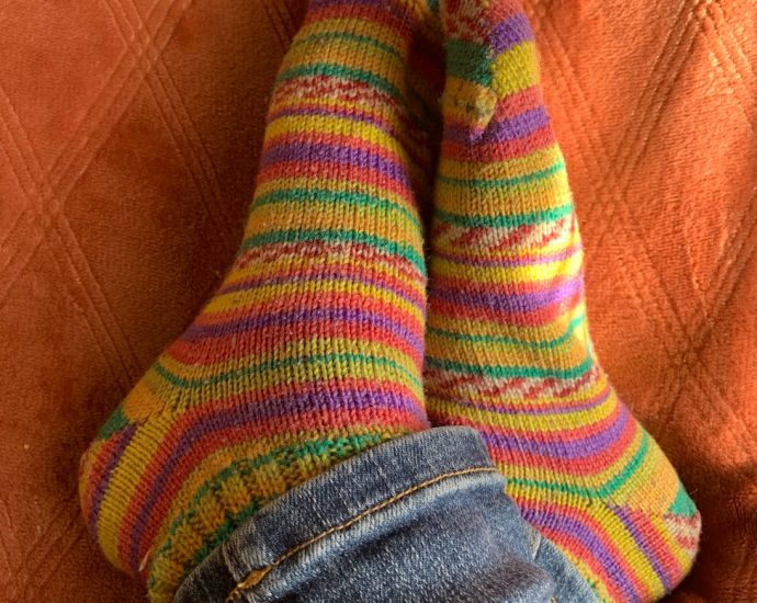 a person s feet in colorful socks sitting on a couch